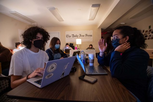 Photo of Campus editor Jesus Marrero Suarez (COM’24), from left, reporter Emilia Wisniewski (COMN’25), and associate campus news editor Tanisha Bhat (CGS’22,COM’24) during print night Feb 24 at The Free Press office. All the students wear masks and a white sign at the back of the room reads "The Daily Free Press"