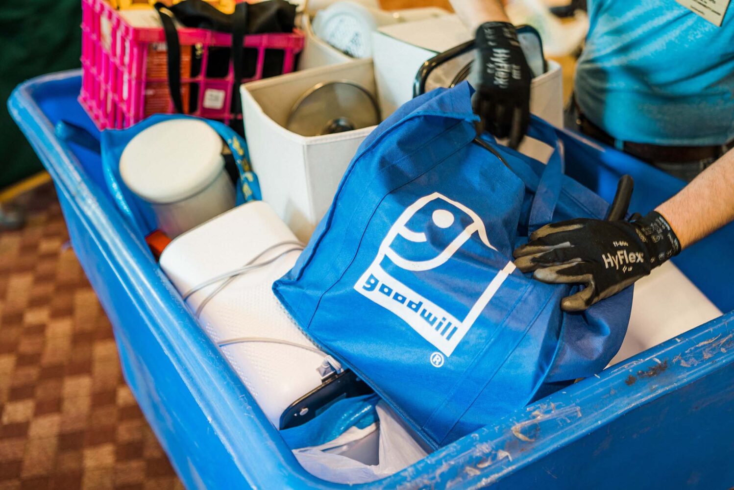Photo: A picture of a blue tote bag with the "Goodwill" logo inside of a large, blue donation bin