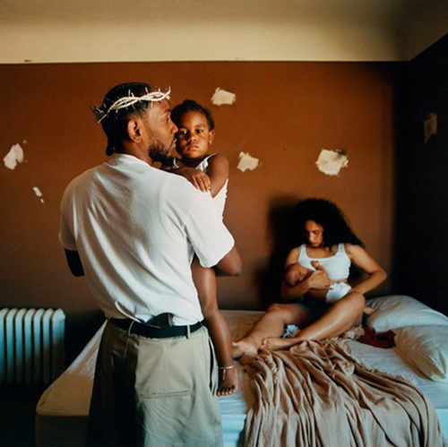 Album cover for Kendrick Lamar's "Mr. Morale & The Big Steppers". Cover is a photo of Kendrick, a Black man wearing a white t-shirt and khaki pants, holding a small brown toddler in his arms. Lamar wears a thorned crown on his head. On the bed in front of him, a Black woman holds a smaller, Black baby in her arms.