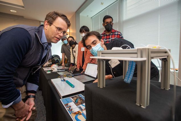 Professor Sean Andersson, left, listens to Franco Julia Wise (ENG’22), at right, as he explains the workings of his team’s Soft Robot with Integrated Soft Optical Sensing for Minimally Invasive Surgery following the May 4 press conference at Phototonics announcing ENG getting $4.4 million from Massachusetts High Technology Council to build a new robotics lab, BU RASTIC, to complement ENG's master's program in robotics and autonomous systems. Photo by Cydney Scott for Boston University Photography