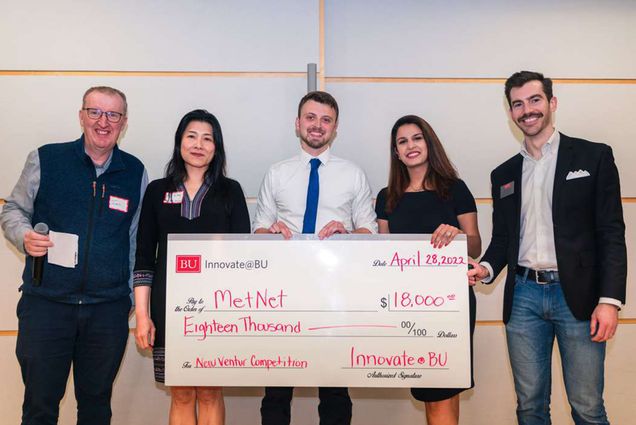 The husband-and-wife duo, Noah (ENG’21) and Astha Flynn (CAS’18, Questrom’23), stood alongside Ian Mashiter, interim executive director of Innovate@BU, Li Liang, managing director of the BUild Lab, and Tom Samph (COM’10), program director of Innovate@BU, after winning an $18,000 check for their start-up, MetNet.