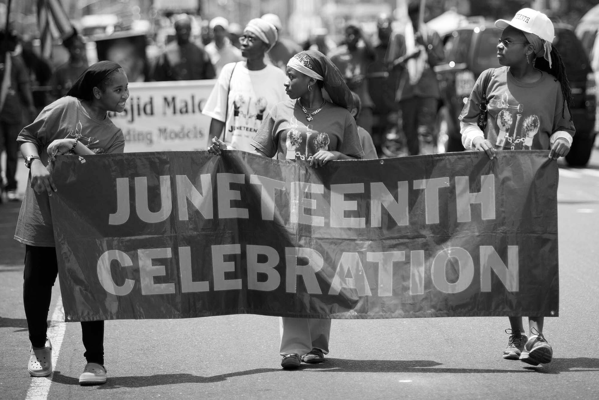 Participants march in the Juneteenth celebration parade, sponsored by the Masjid Malcolm Shabazz, through the streets of Harlem in New York on Saturday, June 18, 2010. Juneteenth, which refers to June 19, 1865, is celebrated as the day the news of the Emancipation reached Galveston, Texas brought by General Gordon Granger and a force of Union soldiers. Their arrival took place 2-1/2 years after Lincoln declared American slaves free on Sept. 22, 1862. (© Richard B. levine) Photo is black and white.