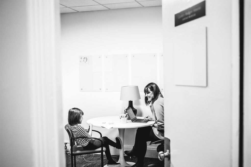 A small child and their parent sit in an office having a conversation. Isla loves to visit her mother’s office in the anthropology department on Bay State Road.