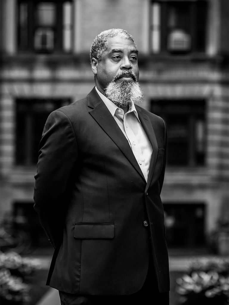 Phillipe Copeland stands confidently in a suit outside in this black and white photo