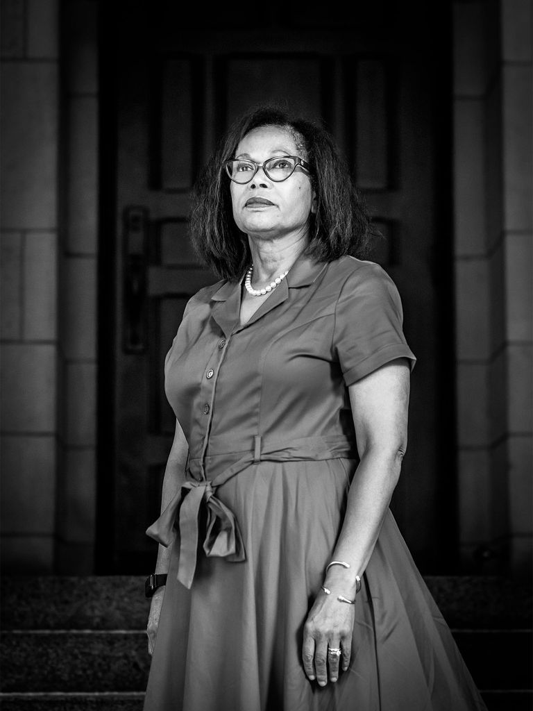 Karen Coleman looks into the distance with her hands at her side in this black and white photo