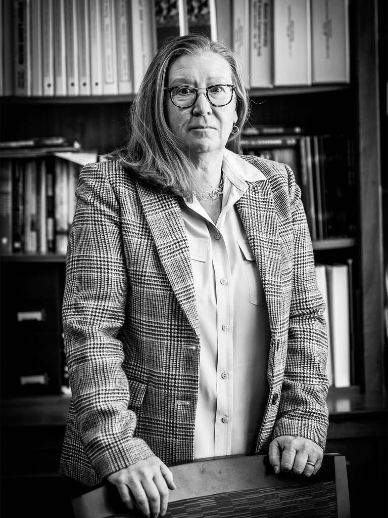 Christine McGuire stares down the camera in what appears to be a library in this black and white photo