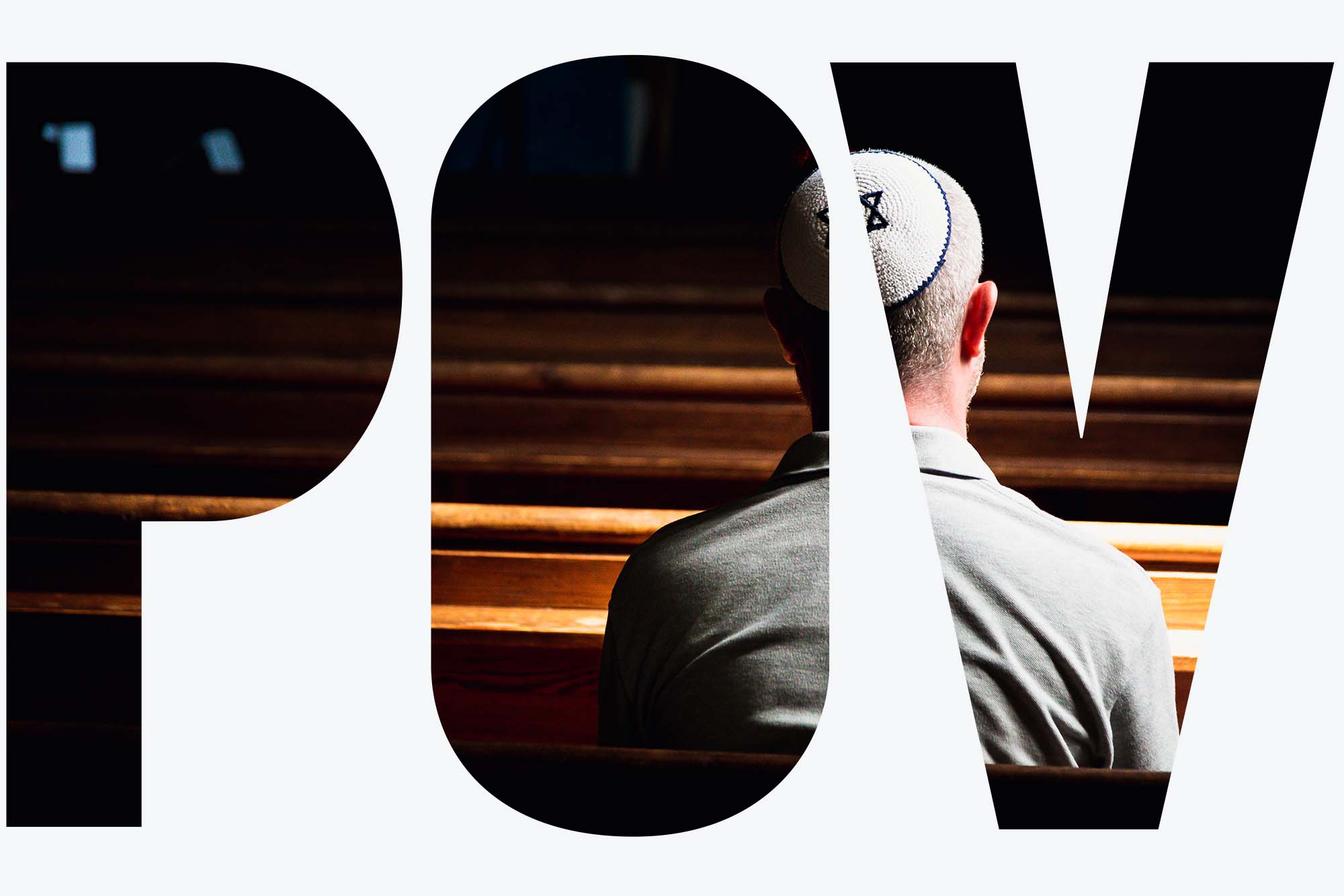 Photo taken from behind a Jewish worshipper as they sit in a synagogue. They wear a blue and white star of David kippah. The space is darkened but they are spotlighted. Overlay reads "POV"