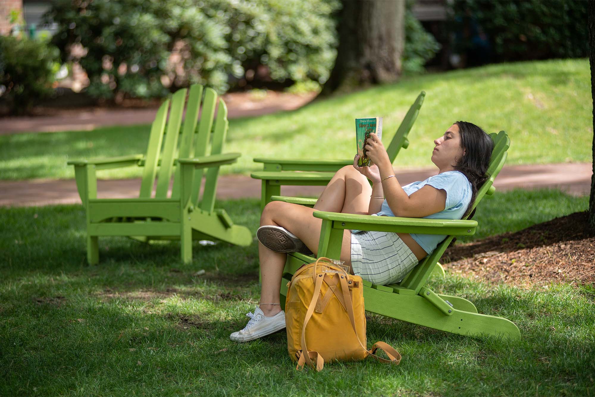 7/27/22 -- Brookline, Massachusetts Madeline Jones (CAS’24) relaxes with an easy read on BU Beach July 27. Jones is on campus taking chemistry courses, so she welcomed the break provided by the classic fantasy novel. Photo by Cydney Scott for Boston University Photography