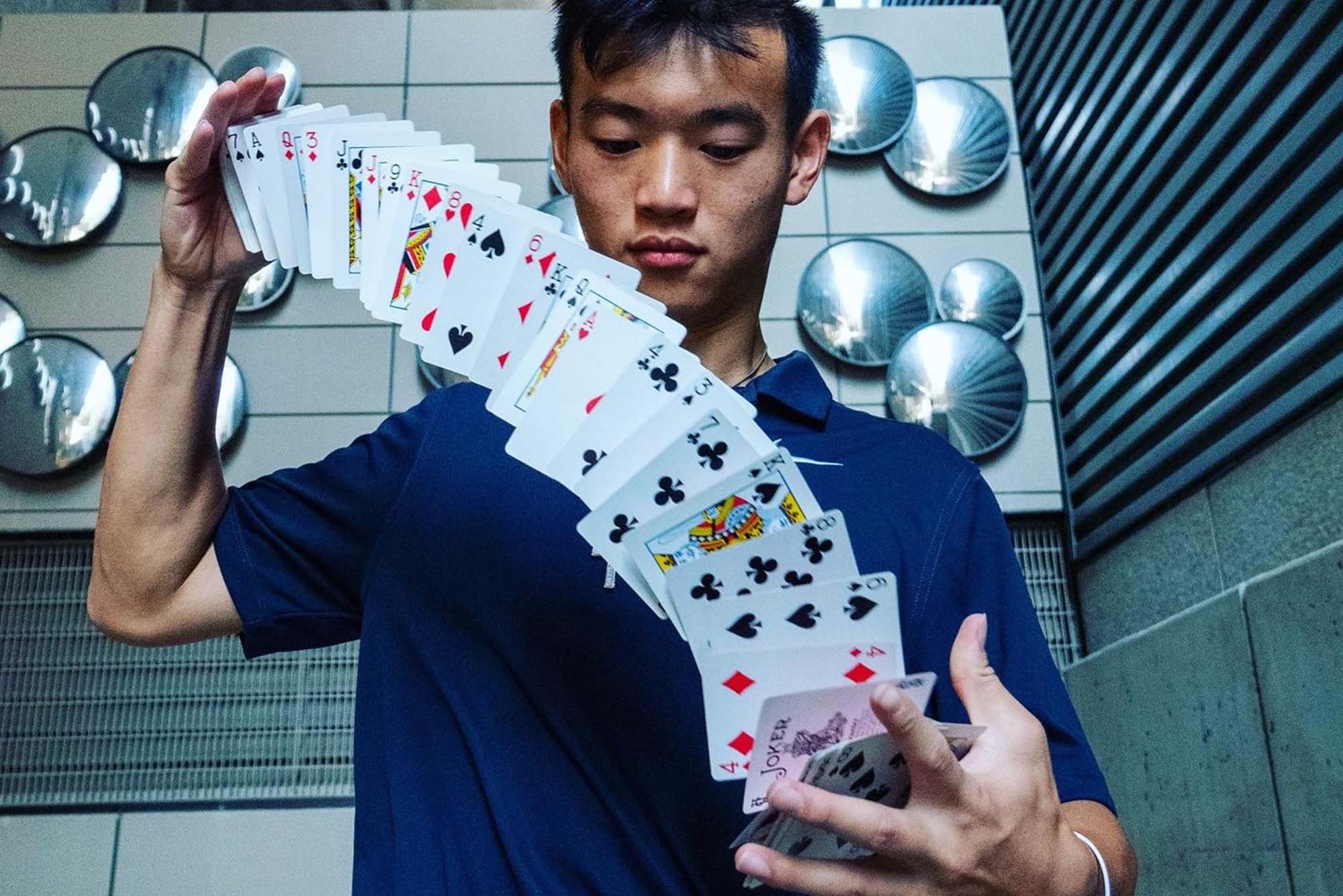 BU student Henry Di—who goes by the stage name Enrique the Magician—performs magic tricks on TikTok. Here he performs a card trick for the camera