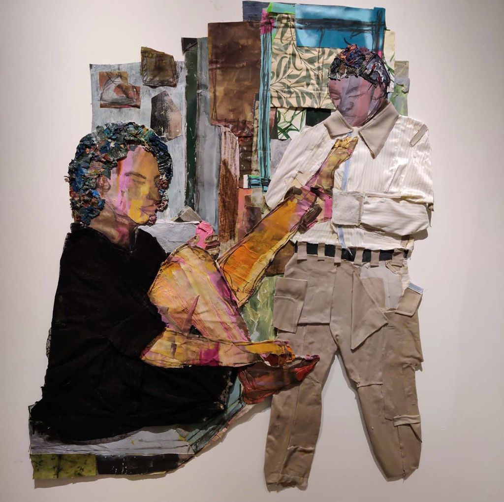 Collage of two people of color, presumably a woman, seated, and a man, standing at right. The woman looks like she's getting ready and has her left leg out towards the man, who holds it by the ankle; perhaps he is helping her put something on. The collage is made from fabric and painted paper. Some lines, such as the legs and faces, are drawn or painted in brown. The back wall is covered with pieces of paper and fabric of various colors and patterns.