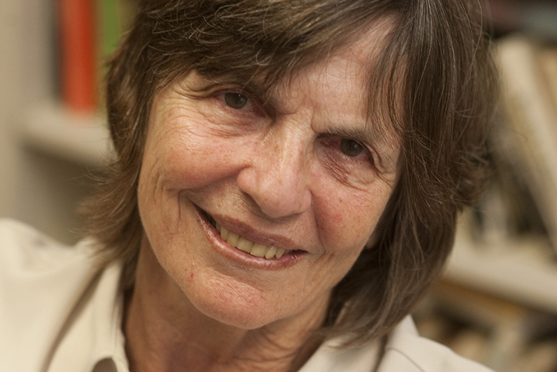 Photo of Susan Eckstein, a light-skinned woman with short brown hair. She smiles and wears a white, collared shirt. 