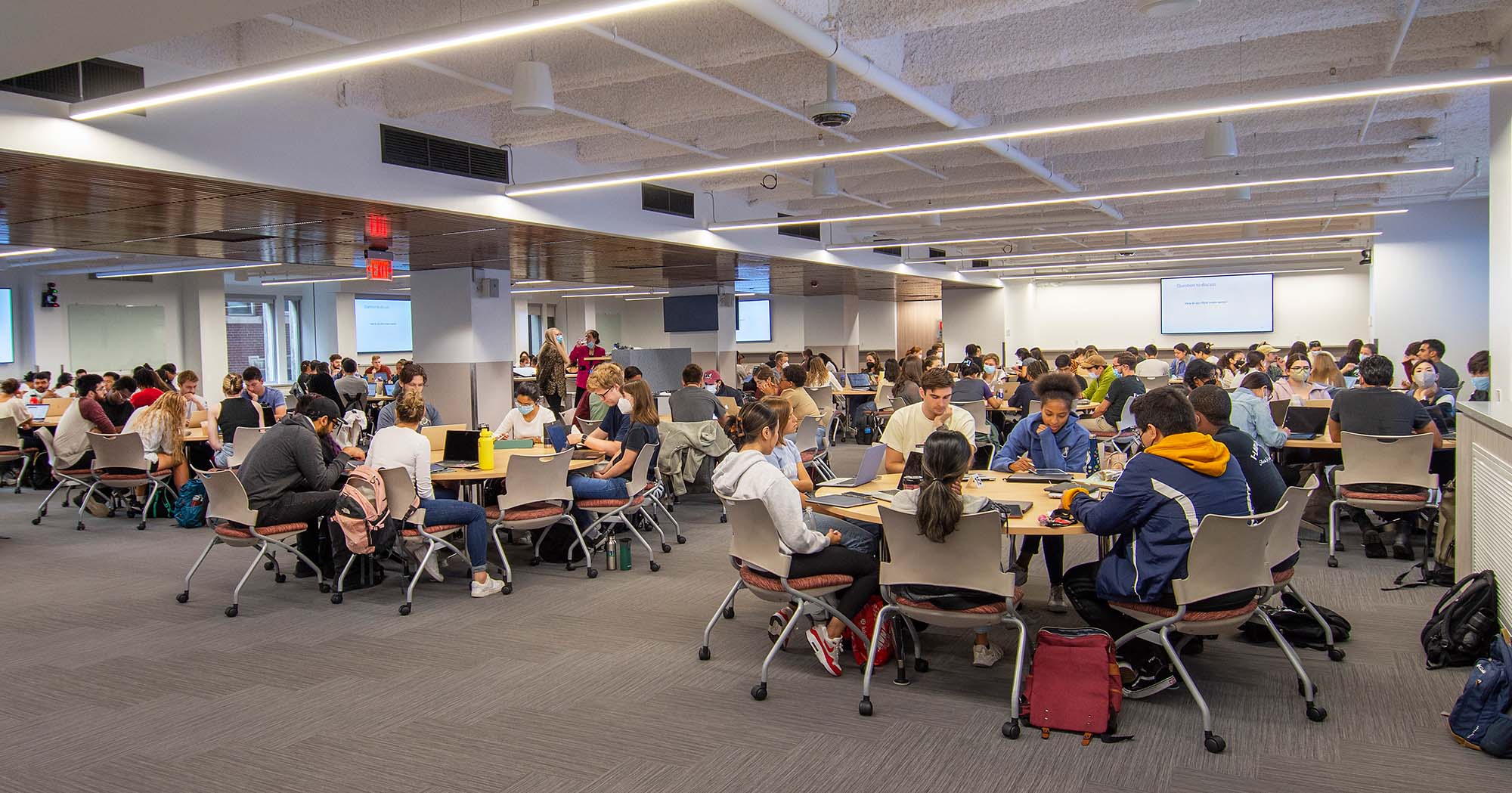 Photo of First-year medical students in the new $5.5 million Learning Center attending a class on gene expression August 22. Students sit in groups around large tables as they work together.