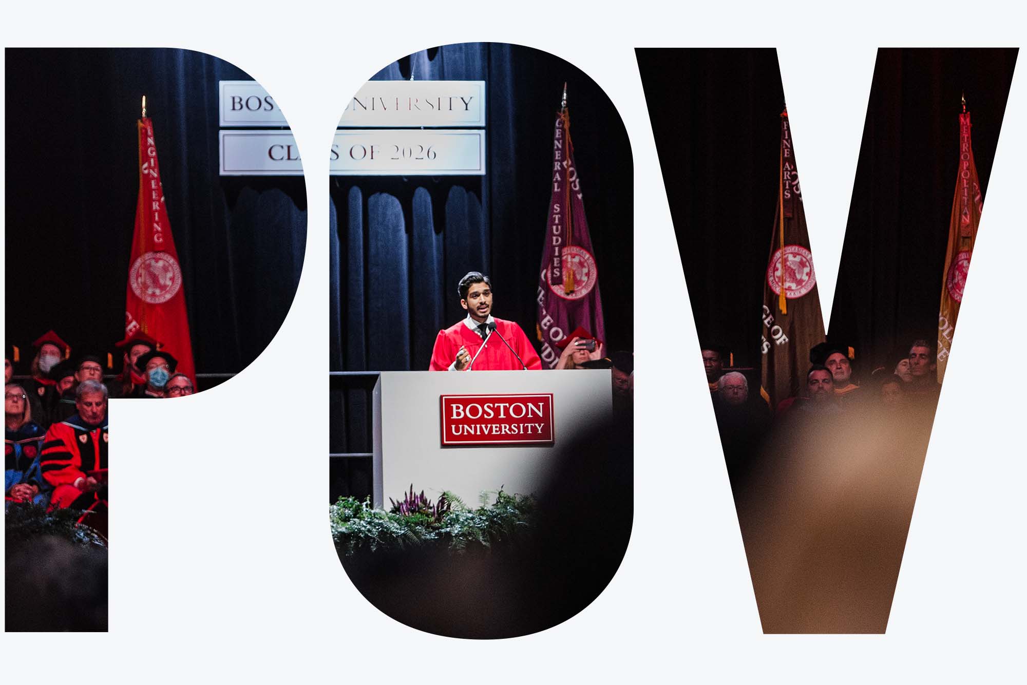 Photo of Dhruv Kapadia giving a speech at BU's 2022 Matriculation. A young South Asian man wearing red robes stands at a podium in front of a stage decorated in black curtains and with a large BU insignia hanging behind him. Blurry students are seen in the crowd in front of him, as other robed officials sit on stage to his left. Image seen through overlay letters "POV"