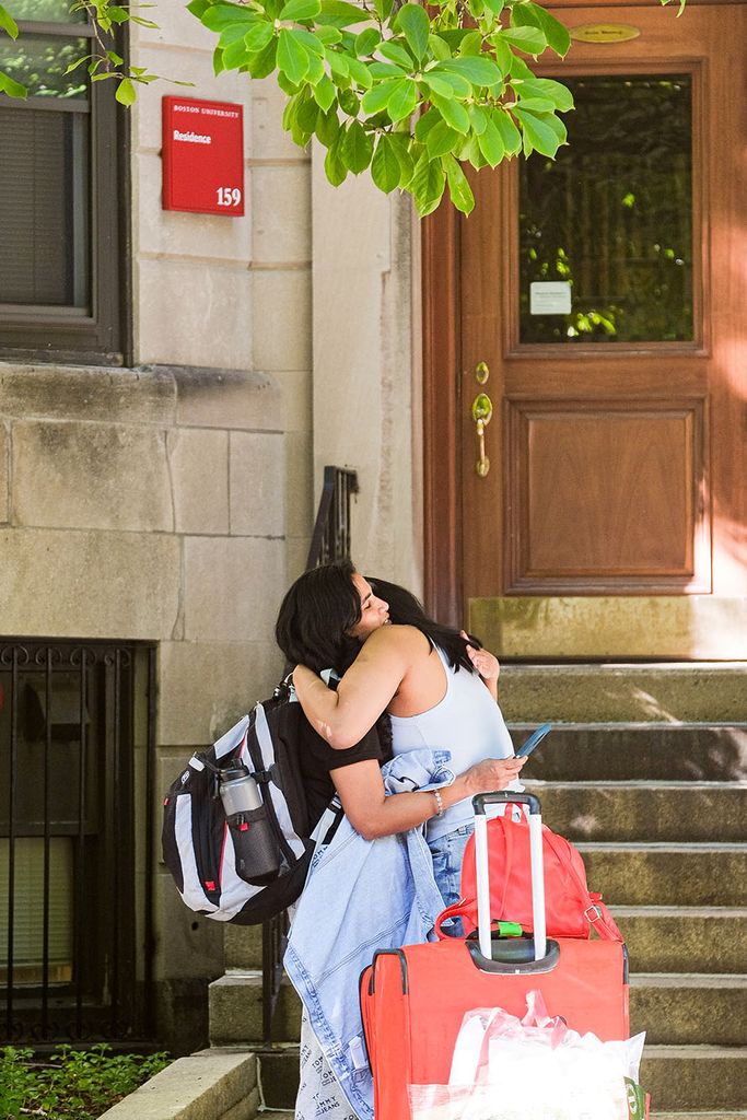 Photo of Adhya Ramganesh (CAS'25) hugging her mother before moving into BU Bay States Residences. A young woman wearing a backpack hugs her mother tightly outside of a brownstone.