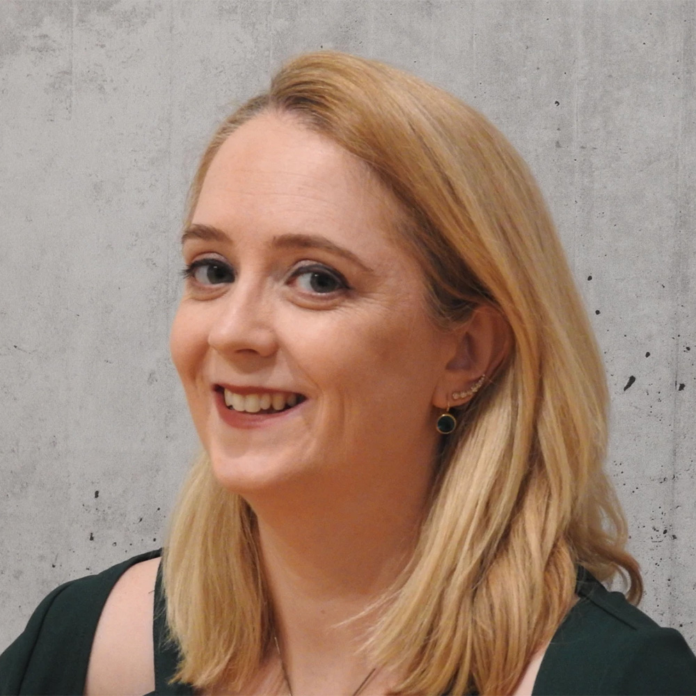 Dr Eleanor Murray smiles for a headshot in front of a white background