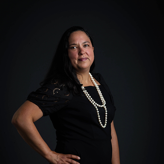 a photo of Asst. Professor of Environmental Health, Diana Ceballos posing in front of a black backdrop.