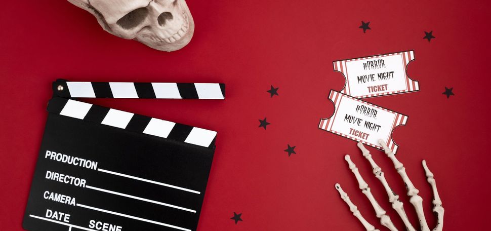 A movie clapperboard and halloween decoration. Horror movie night.
