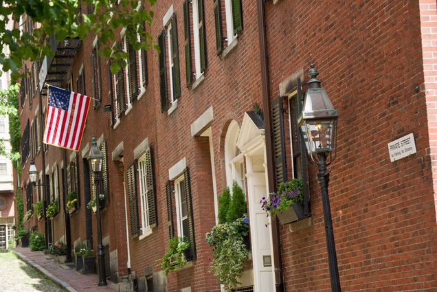 Stock photo of Beacon Hill in Boston. A brick building along a cobblestone street is shown.