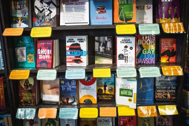 A photo at Brookline Booksmith where banned books are available for purchase. The books displayed have cards explaining when, where, and why the book was banned.