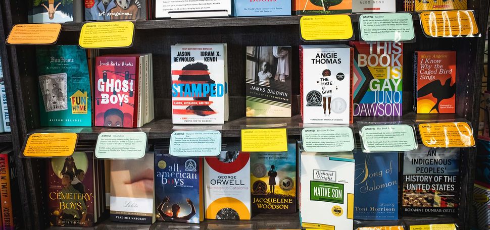 A photo at Brookline Booksmith where banned books are available for purchase. The books displayed have cards explaining when, where, and why the book was banned.