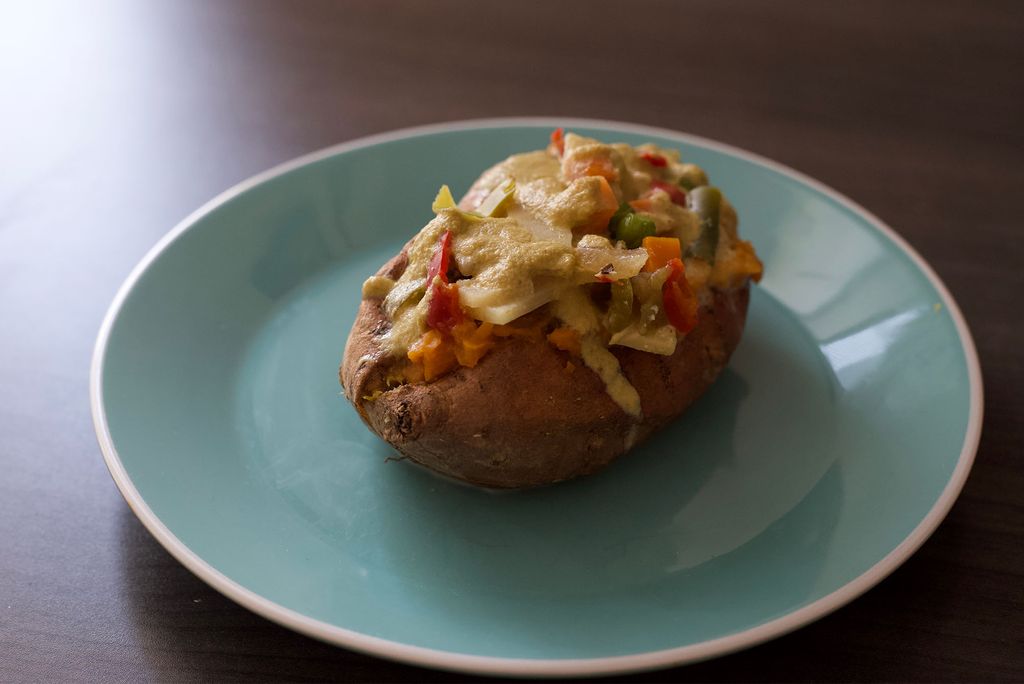 You need only a microwave to make these delicious sweet potatoes topped with an easy, zingy veggie green curry. A picture of a sweet potato with green curry and vegetables on top. Photo by Mara Sassoon