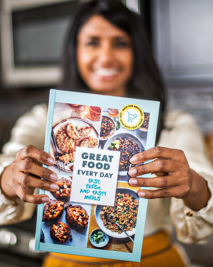 Photo of Priya Shah, wearing a white ruffly blouse, holding a sample LVNGbook in front of her. The cover reads "great food everyday" and features colorful photos of food.