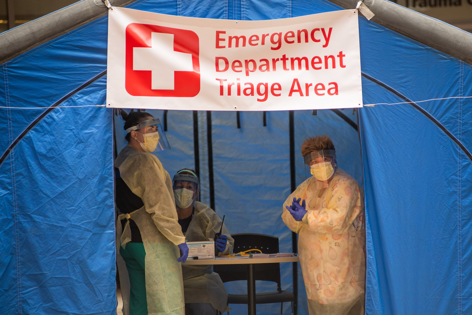 Nurses wait for patients outside Boston Medical Center during the early days of the pandemic, March 20, 2020. The staff inside the triage tent assessed patients’ symptoms and determined whether they could receive care through BMC’s influenza-like illness clinic (ILI) for more moderate symptoms, or if they needed to go to the Emergency Department for more serious conditions. The COVID-positive patient census at BMC skyrocketed from 22 patients on March 24, 2020, to 121 patients in just eight days, and reached 219 by April 9.