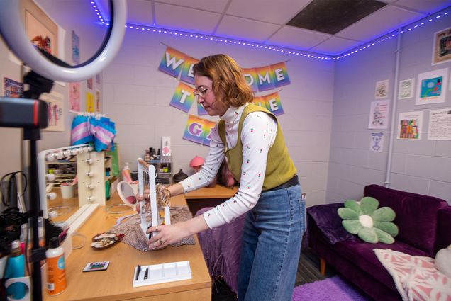Kaylan Comenole (CGS’21, CAS’23), director of BU’s Center for Gender, Sexuality, & Activism (CGSA), adjusts a rack of jewelry in the center’s new Gender Affirming Room for Belonging (GARB). Students can choose items like chest binders, bra inserts, shaving supplies, clothing, and accessories. No appointment is needed to access GARB. Photo by Cydney Scott