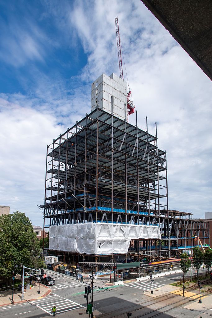 Vertical photo of construction at the Data Science Center at 645-665 Commonwealth Avenue that shows the height of the building. A red crane and concrete elevator shaft stretch into the blue sky.