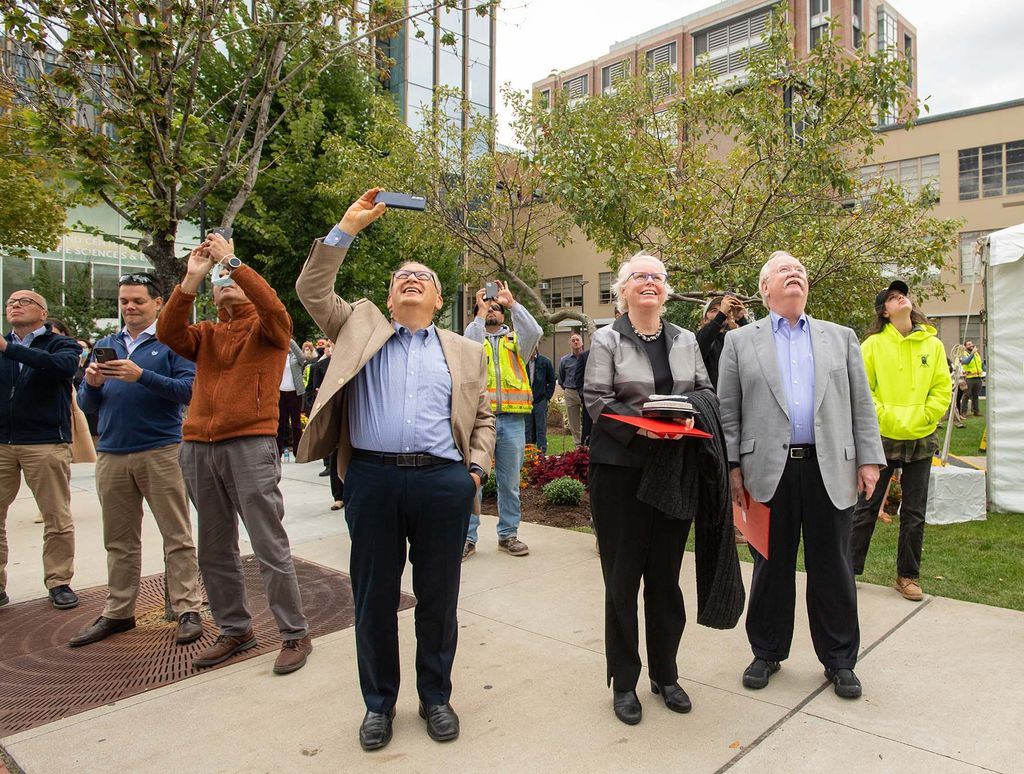 Photo: Onlookers watch and look above as the final beam is put into place during the Topping Off ceremony at the Data Sciences Building September 30.