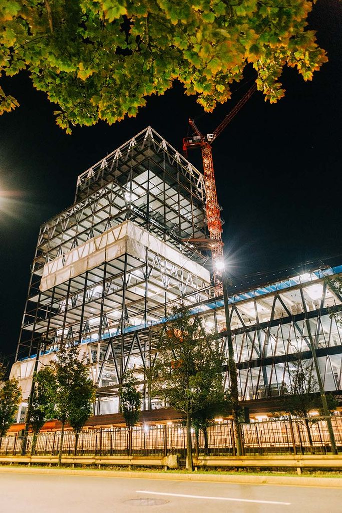 Photo:  Construction of the Center for Computing & Data Sciences. The metal framework of the building is shown lit up during the night.