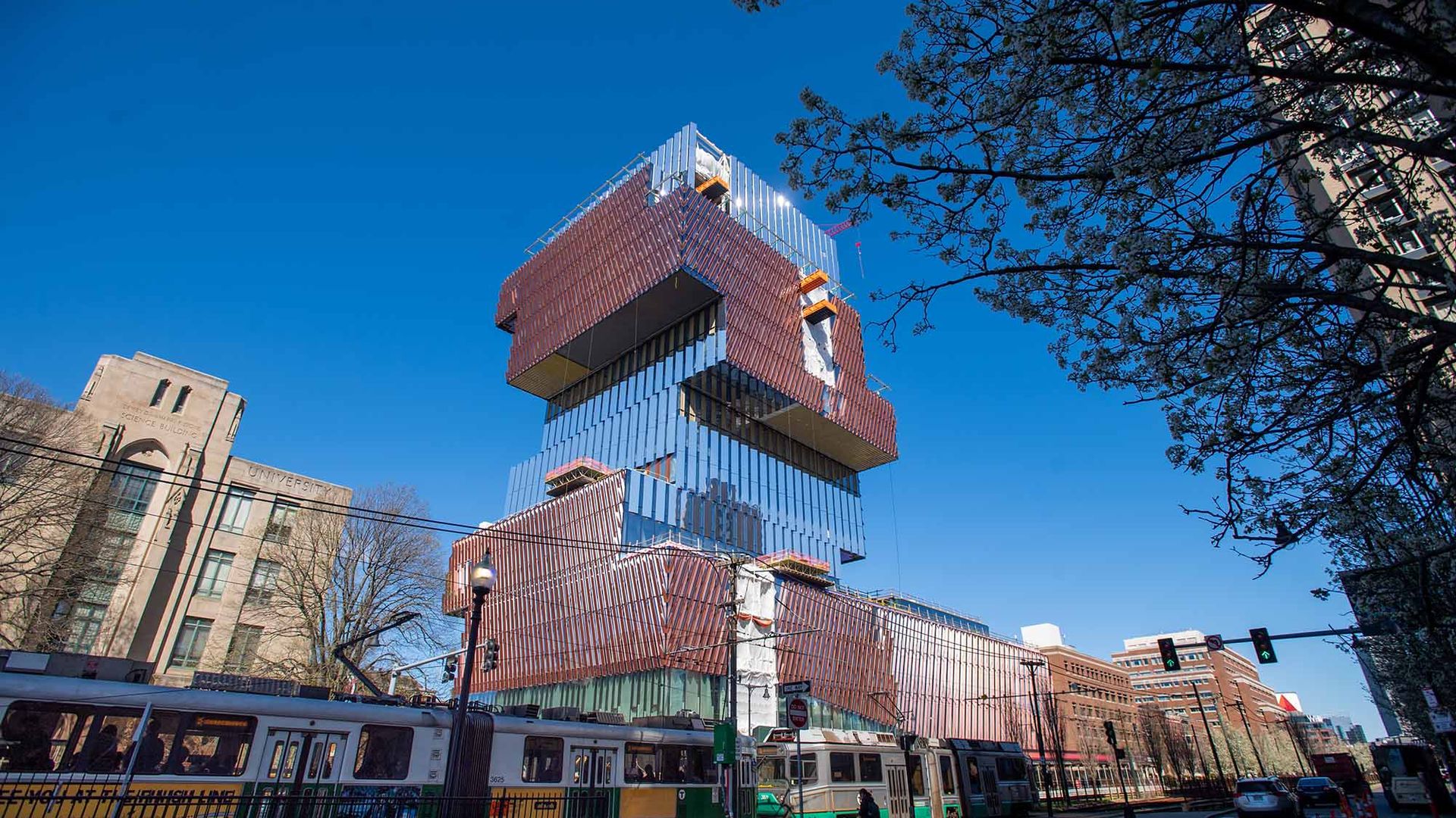 Photo: View of the Center for Computing and data Sciences from Commonwealth Ave April 20. From this viewpoint, the sides of the building alternate a copper color and a reflective mirror side.