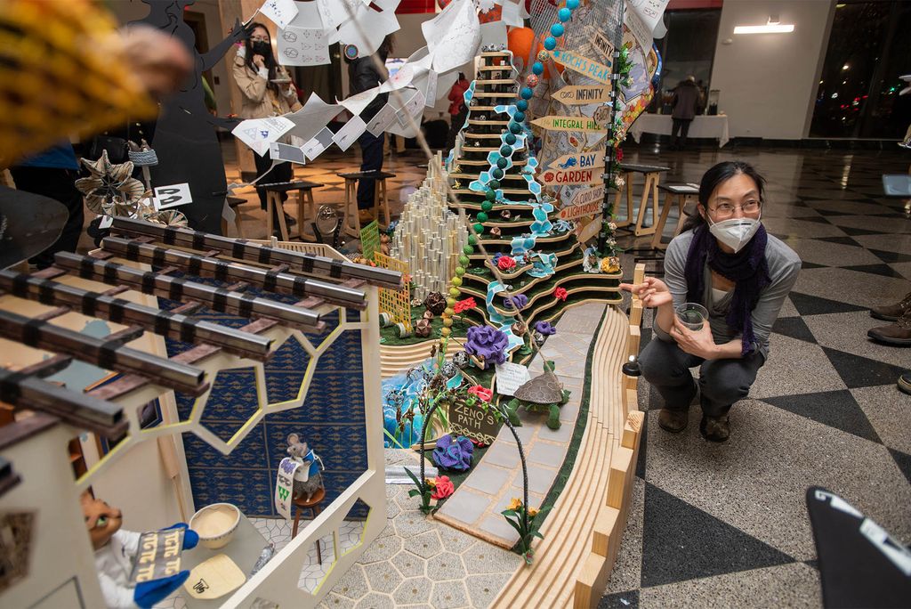 Li-Mei Lim, a research professor of mathematics and statistics at CAS, explains the “Zeno’s Paradox” section of Mathemalchemy to visitors at the installation’s opening reception on January 20.