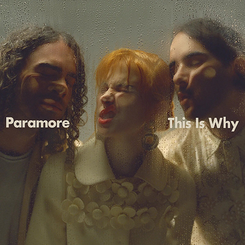 Cover art shows Paramore’s Taylor York, Hayley Williams, and Zac Farro, a white man with long, curly brown hair, a white woman with bright orange hair, and a white man with short brown hair,  pressing their faces against a piece of glass. White text reads "Paramore, This is Why".