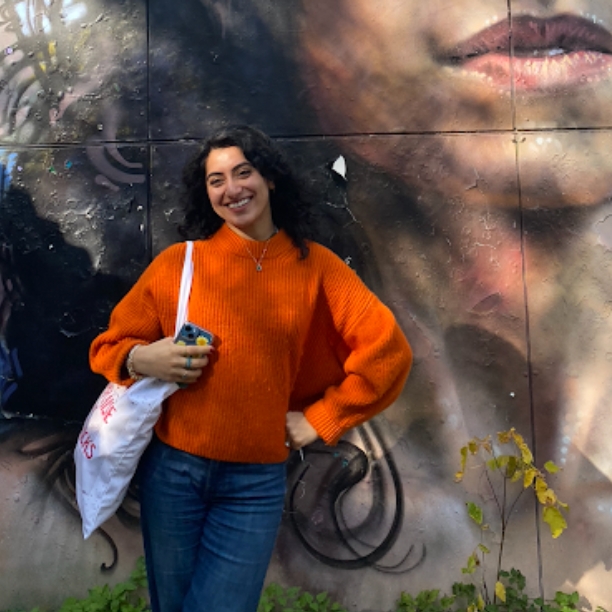 Photo: Seema Thakkar (CAS’24) standing in front of a mural.