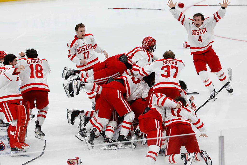 Photo: BU Men's hockey dog-pile while they celebrate their overtime win for their 10th Hockey East title.