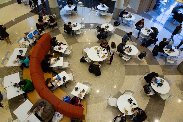 Photo: Students sit in a circular pattern in a Boston University dining hall during a busy meal service