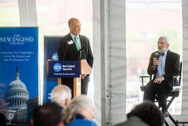 Photo: Dennis Carlberg, associate vice president for BU Sustainability (a white man wearing a suit on the right), speaks on a panel about climate change in the region at the New England Aquarium on May 23. Helping moderate the event was Peter J. Howe (left), senior vice president of Boston public relations firm Denterlein.