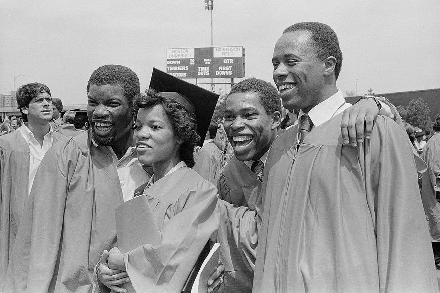 Photo: A group of four happy black graduates at the Boston University Commencement on Nickerson Field on May 16, 1982.