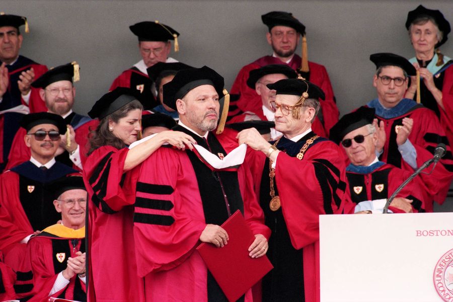 Photo: August Wilson, a white man with a beard, is hooded by a BU Trustee and BU President John Silber for receiving an honorary degree at Boston University's 1996 Commencement exercises on Nickerson Field on May 19.