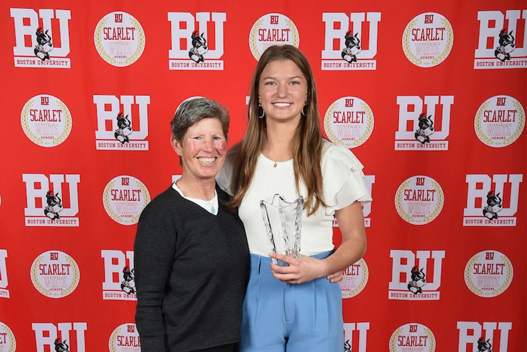 Photo: Rachel Borzymowski, a young white woman stands next to an older white woman in front of a red Boston Unversity background