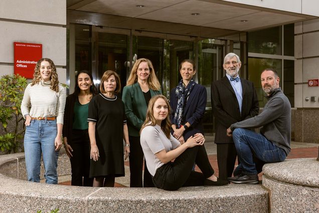 Photo: A group of people pose in font of a building with glass doors. Pictured (from left): Saylor Williams, Manpreet Singh (GRS’24), Gloria Waters, Rebecca Pearl-Martinez, Golden (CAMED’27); Angie Serrano, a BU medical school assistant professor of vascular biology; Dennis Carlberg, and Greg Miller.