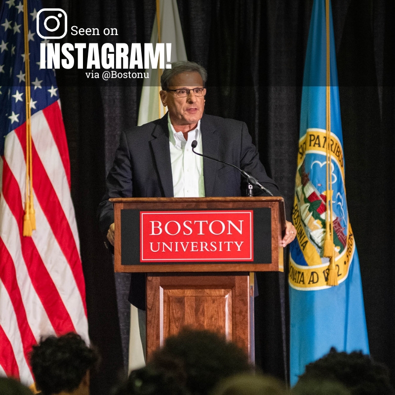 Photo: Dean Kenneth Lutchen, a white man in a gray suit wearing glasses, stands at a podium during the the NASA Downlink event with astronaut Bob Hines, PhD (ENG’97) in the GSU July 20. Text overlay reads SEEN ON INSTAGRAM VIA @BOSTONU
