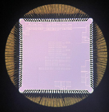 Photo: Close up image of a purple sensor microchip. Shown on a black background.