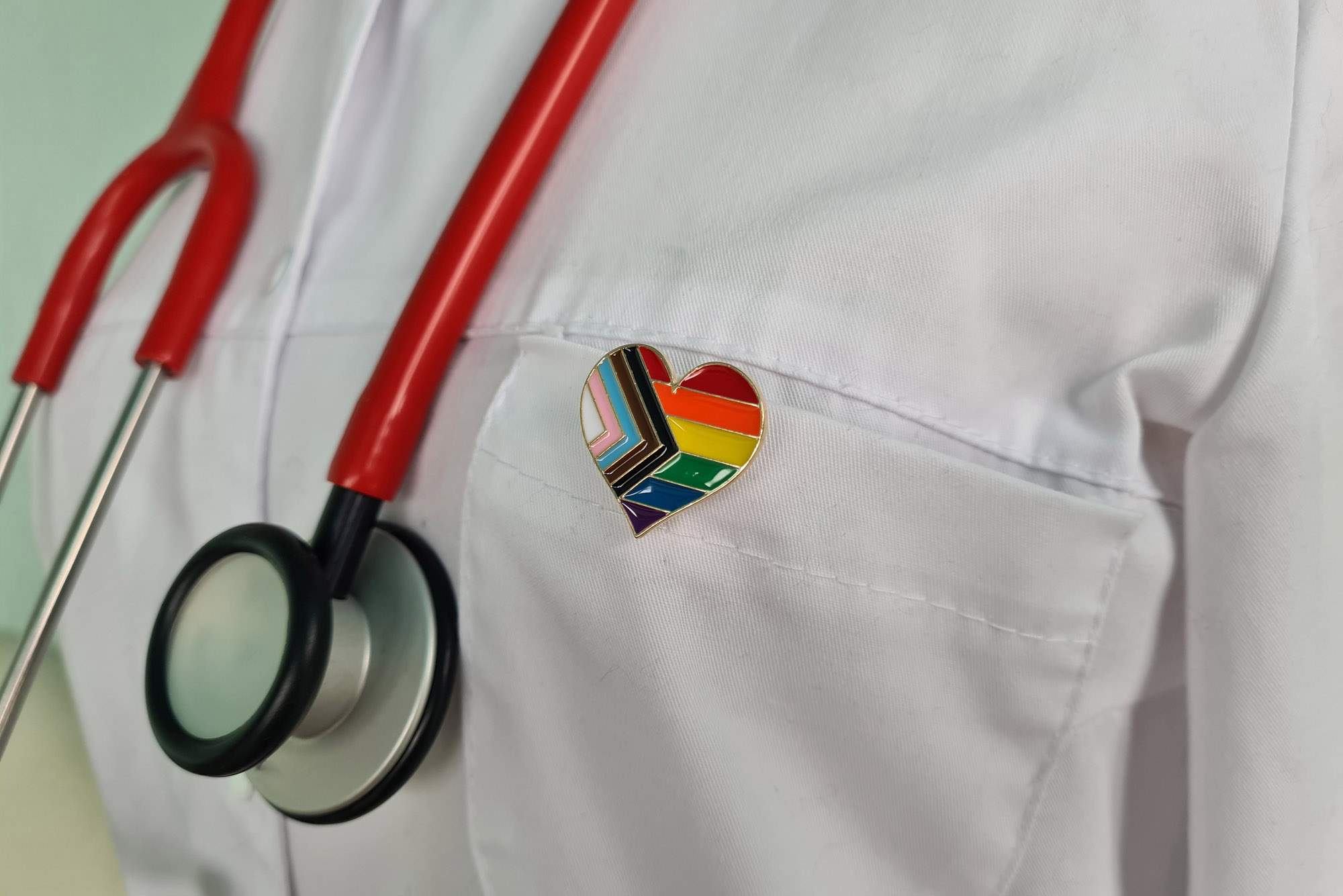 Photo: Silhouette of doctor in white coat with stethoscope and LGBT badge on pocket