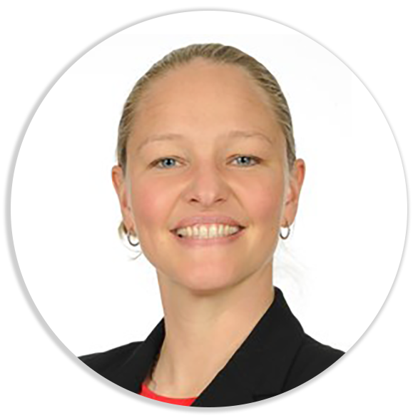 Portrait of Bowers on a white background. She is a white woman with blonde hair that is pulled back. She wears small hoop earrings and a black blazer and smiles.