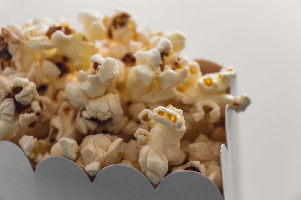 Photo: Popcorn in a white bag with a white background.