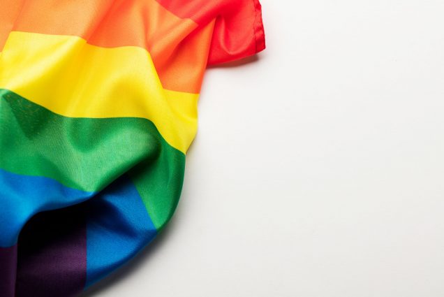 Photo: Part of an LGBT rainbow flag is shown casually lying on a white background.