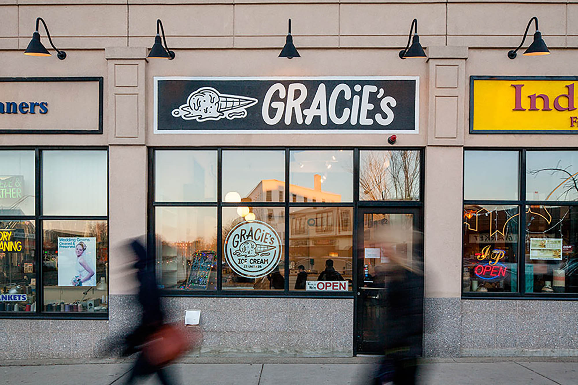 Photo: A beige storefront with an all black sign and white lettering that reads GRACIE'S.