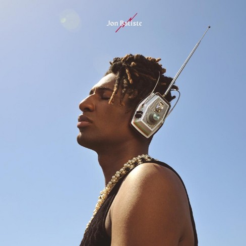Photo: A man with old headphones on stares to the left. He is contrasted against a clear, blue sky.